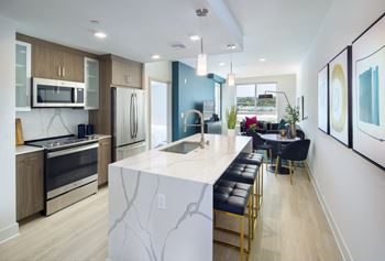 a kitchen with an island and a dining room with a table and chairs